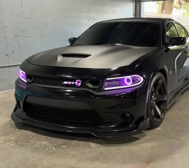 Black Dodge Charger Scat Pack with purple headlight halos inside the shop