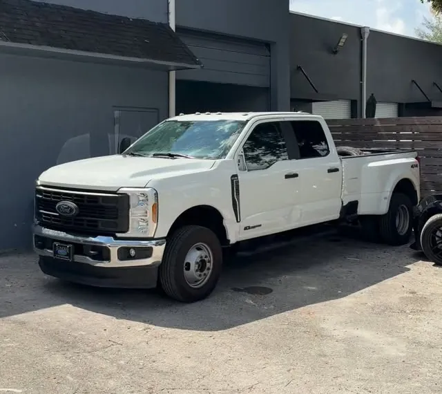 White Ford F-350 dually pickup outside the shop after the fender and door repair